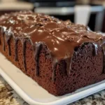 A slice of chocolate pound cake on a plate.