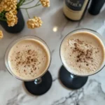 A close-up of an espresso martini recipe with Baileys in a martini glass, garnished with coffee beans.